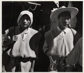 <span itemprop="name">Two young men in tunics and hats at the market...</span>