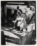 <span itemprop="name">Women washing dishes and pots and pans in an...</span>