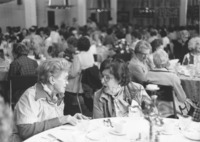 <span itemprop="name">Two unidentified women speaking at a luncheon...</span>