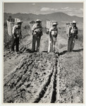 <span itemprop="name">Four men wearing hats with large baskets on their...</span>