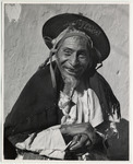 <span itemprop="name">An old man with a hat and shawl draped over his...</span>