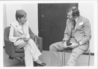 <span itemprop="name">A photograph of two unidentified people talking at...</span>
