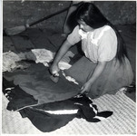 <span itemprop="name">A young woman kneels while she irons clothes on...</span>