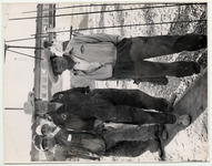 <span itemprop="name">Four young men in hats standing on a dusty gravel...</span>