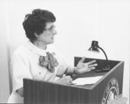 <span itemprop="name">Josephine Wise speaking from a podium during a...</span>