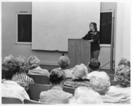 <span itemprop="name">An unidentified woman speaking to an audience from...</span>