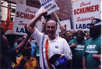 <span itemprop="name">United States Senator Chuck Schumer wears a sash...</span>