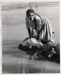 <span itemprop="name">Girl washing clothes in shallow waters, at the...</span>