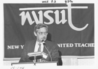 <span itemprop="name">John M. "Tim" Reilly speaks from a podium during a...</span>