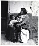 <span itemprop="name">A woman in a white skirt sitting with a young girl...</span>