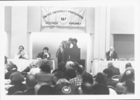 <span itemprop="name">Tim Reilly standing at podium with an unidentified...</span>