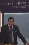 <span itemprop="name">An unidentified person speaking at the podium at...</span>