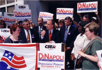 <span itemprop="name">Tom DiNapoli speaks to a crowd of unidentified...</span>