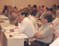 <span itemprop="name">Unidentified persons listen to a presentation at...</span>