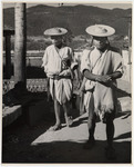 <span itemprop="name">Two men in white garb and flat straw hats walking....</span>