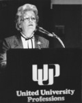 <span itemprop="name">Rita Piccolo speaking from a podium during an...</span>