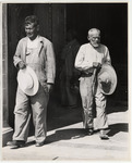 <span itemprop="name">Two men holding their hats in their hand walking...</span>