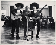 <span itemprop="name">Three Mariachi muscians with guitars singing into...</span>