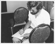<span itemprop="name">An unidentified man writing on a piece of paper...</span>