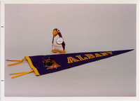 <span itemprop="name">Page 129: Old mascot "Pierre the Ped-guin" and a new banner with the Great Dane mascot.</span>